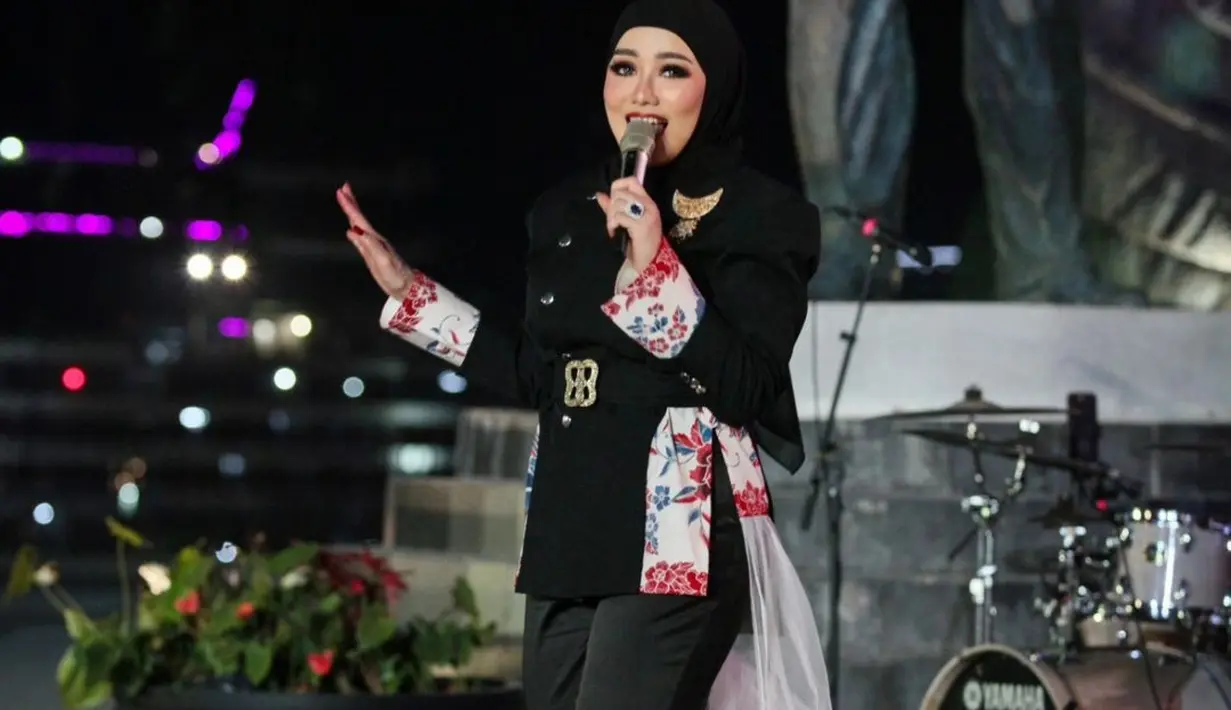 Momen keseruannya saat manggung di IKN dibagikan lewat akun Instagram pribadinya. Salah satu yang tak luput dari sorotan adalah penampilannya yang elegan. Ibu Aaliyah Massaid itu tampil menawan dengan mengenakan busana serba hitam berupa beskap dengan sentuhan batik rancangan desainer ternama Wilsen Willim. [@rezaartameviaofficial].