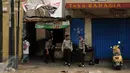 Beberapa petugas kepolisian berjaga di salah satu gang masuk menuju kawasan Kampung Pulo Jakarta, Jumat (21/8/2015). Ribuan aparat gabungan terus berjaga mengawal proses penggusuran warga Kampung Pulo Jakarta Timur. (Liputan6.com/Helmi Fithriansyah)