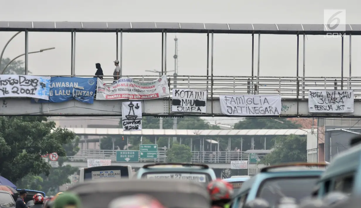 Spanduk dukungan Persija yang terpasang di JPO, Jakarta, Minggu (9/12). Jelang laga penentuan pekan ke-34 Liga 1 antara Persija melawan Mitra Kukar, spanduk dukungan juara The Jakmania bermunculan di JPO jalan Ibu Kota. (Merdeka.com/Iqbal S. Nugroho)