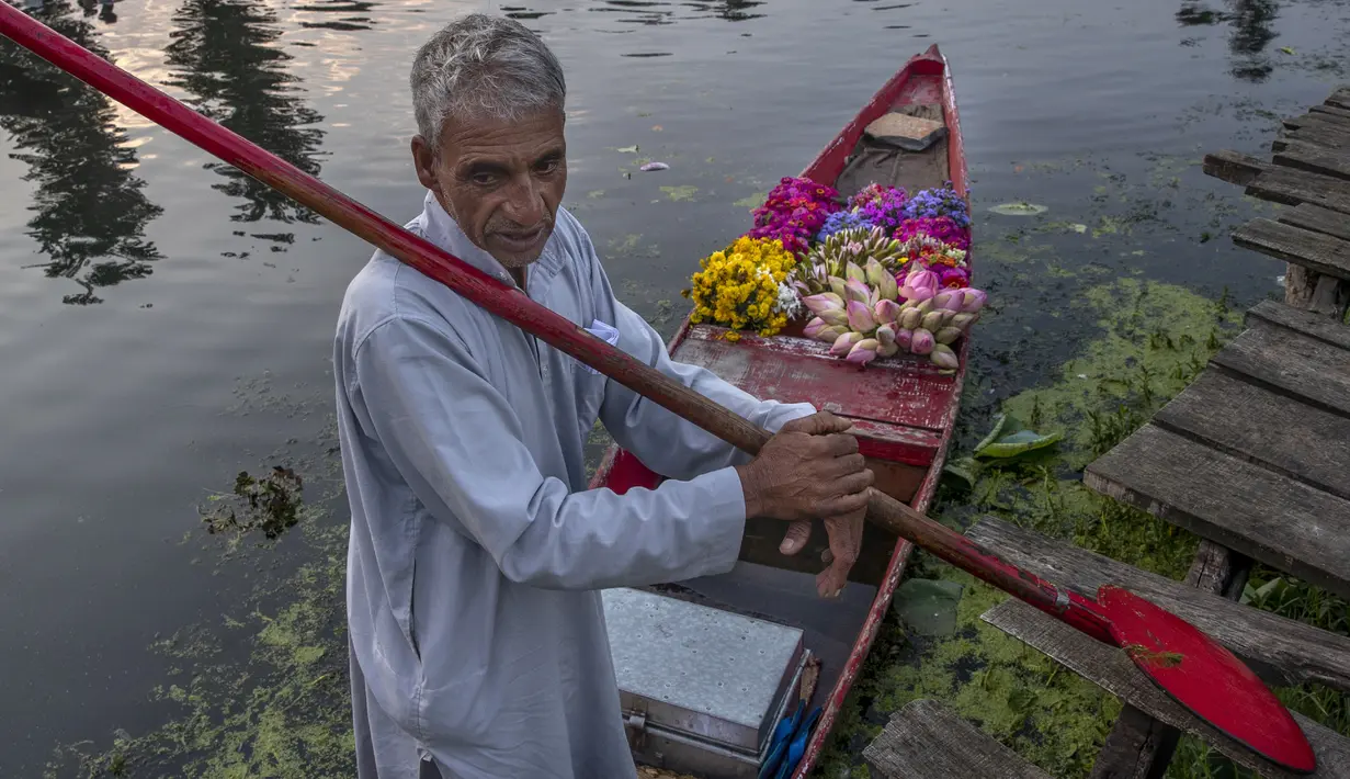 Seorang penjual bunga Kashmir menunggu pelanggan saat ia berdiri di atas perahunya di pasar sayur terapung di Danau Dal, Srinagar, Kashmir, India, Sabtu (7/8/2021). Pasar terapung ini menjadi salah satu sumber pendapatan utama penghuni Danau Dal. (AP Photo/Dar Yasin)