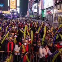 Orang-orang berkumpul saat perayaan malam Tahun Baru di Times Square, New York City, Amerika Serikat, Jumat (31/12/2021). (Yuki IWAMURA/AFP)