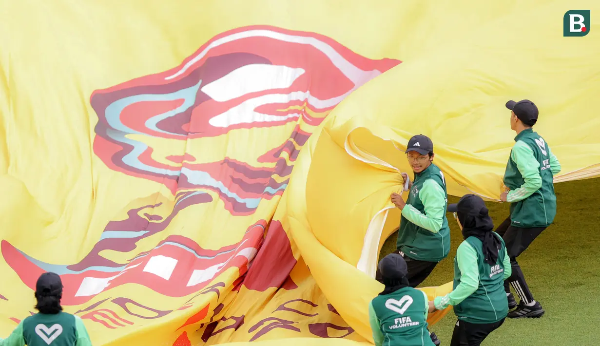 Sejumlah petugas berusaha membentangkan bendera sebelum laga Piala Dunia U-17 2023 antara Timnas Mali U-17 melawan Timnas Kanada U-17 di Stadion Gelora Bung Tomo (GBT), Surabaya, Kamis (16/11/2023). (Bola.com/Bagaskara Lazuardi)