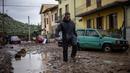 Seorang pria berjalan di lumpur di Montemurlo setelah hujan deras, pada 3 November 2023. (Federico SCOPPA/AFP)