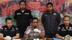 Kabid Humas Polda Metro Jaya Kombes Argo Yuwono (tengah) menunjukkan tersangka jual beli narkoba liquid vape di Jakarta, Kamis (25/10). Tersangka menjual dan menjadi kurir narkoba liquid vape di medsos Instagram dan Line. (Liputan6.com/Immanuel Antonius)