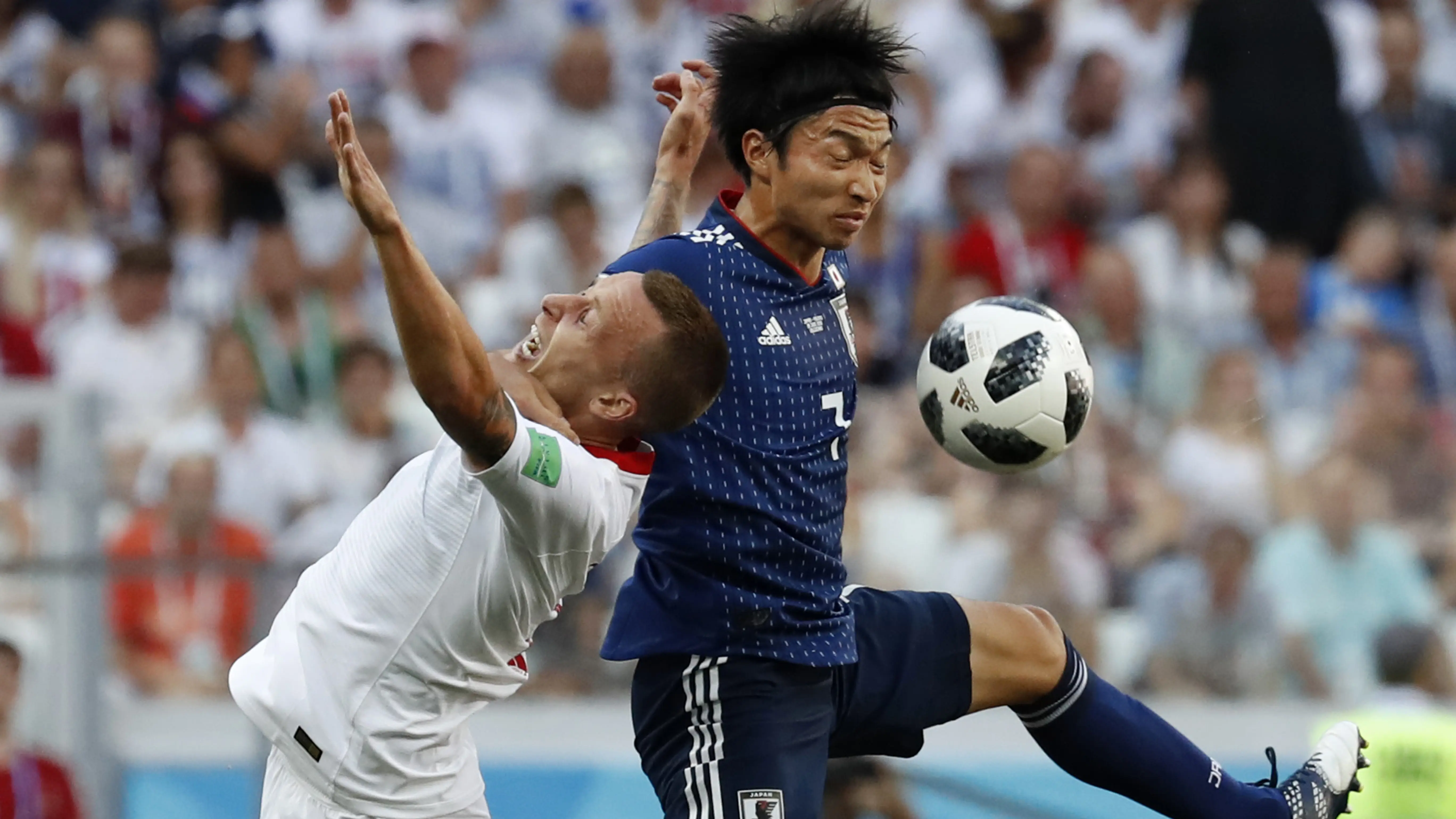 Duel pemain Jepang, Gaku Shibasaki (kanan) dan pemain Polandia, Jacek Goralski pada laga terakhir grup H di Volgograd Arena, Volgograd, Rusia (28/6/2018). Jepang kalah 0-1 dari Polandia. (AP/Eugene Hoshiko)