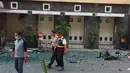 Petugas kepolisian berjalan melewati puing-puing pascaledakan bom di Gereja Santa Maria, Surabaya, Minggu (13/5). Selain di Gereja Katolik Santa Maria, dua ledakan lain di Gereja Pantekosta Pusat Surabaya dan Gereja Kristen Jawi Wetan. (AP/Trisnadi)