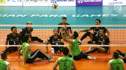 Tim voli duduk putra Indonesia bersiap menghadang smash pemain Iraq saat berhadapan pada pertandingan Asian Para Games di GBK, Jakarta, Senin (8/10). Indonesia kalah dari Iraq dengan skor 25-11, 25-10, dan 25-10. (Merdeka.com/Imam Buhori)