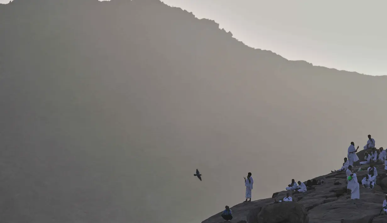 Umat Muslim berdoa di puncak bukit berbatu yang dikenal sebagai Jabal Rahmah atau Gunung Rahmat, di Dataran Arafah, selama ibadah haji tahunan di dekat kota suci Mekah, Arab Saudi, Selasa 26 Mei 2026. (AP Photo/Altaf Qadri)
