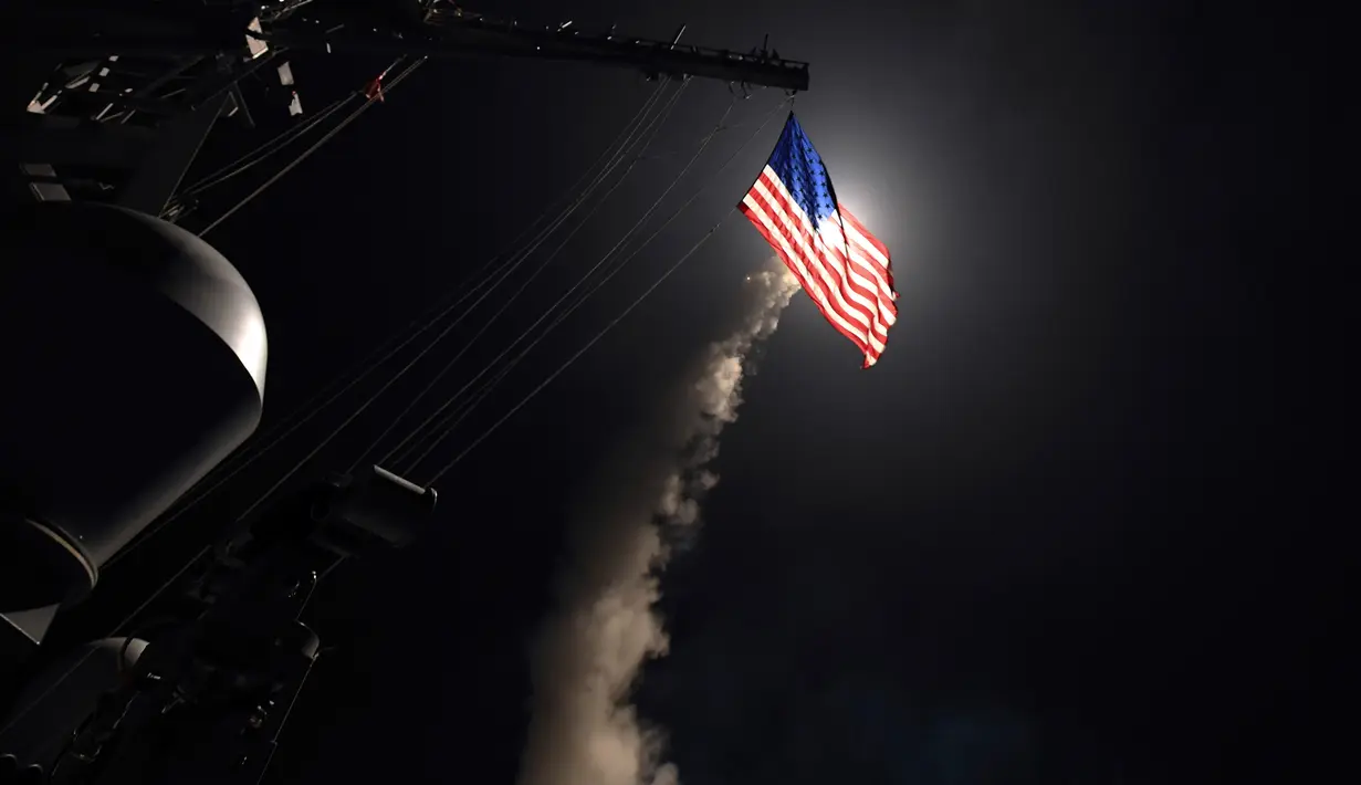 Militer AS meluncurkan rudal Tomahawk dari kapal perang AS yang ada di Laut Mediterania, ke pangkalan udara Suriah, Jumat (7/4). Sekitar 60 rudal Tomahawk ditembakkan dari atas kapal perusak USS Ross (DDG 71). (MC3 (SW) Robert S. Price /U.S. Navy via AP)