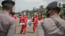 Aktivis melakukan happening art di kawasan Patung Kuda, Jakarta, Selasa (15/12/10). Aksi ini merefleksikan potret Indonesia di tahun 2020 #bersikanIndonesia, di tahun kelam bagi demokrasi yang dipertontonkan di ruang publik seperti brutalitas aparat dan pelanggaran HAM. (Liputan6.com/Faizal Fanani)