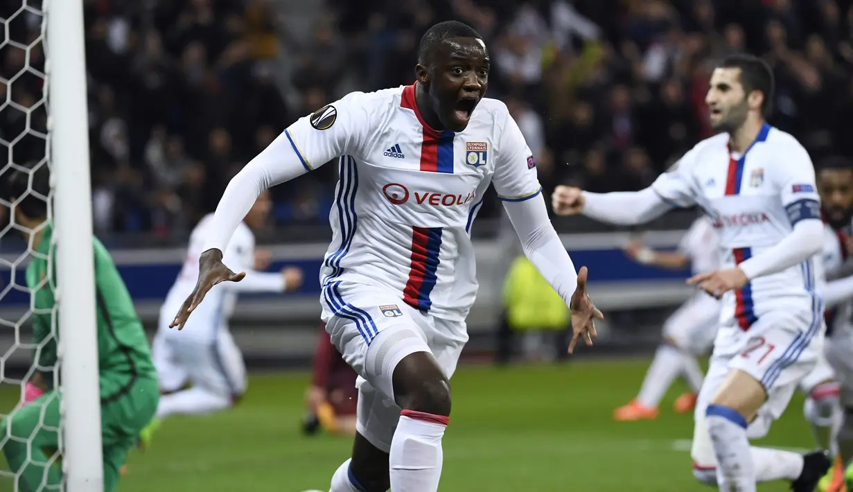 Bek Lyon, Mouctar Dikhaby melakukan selebrasi usai mencetak gol ke gawang AS Roma pada leg pertama babak 16 besar Liga Europa di Stade de Lyon, Prancis, (9/3). Lyon berhasil mengalahkan AS Roma dengan skor 4-2. (AFP Photo / Philippe Desmazes)