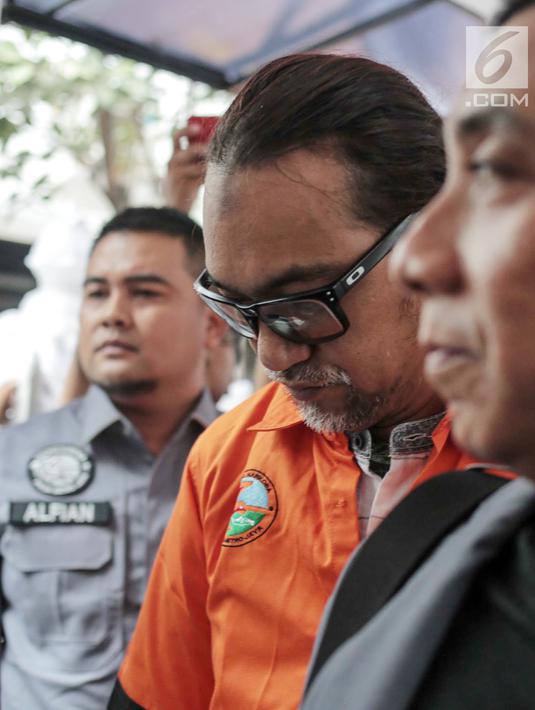 Suami komedian Tri Retno Prayudati alias Nunung, July Jan Sambiran tertunduk saat akan rilis kasus narkoba di Ditnarkoba Polda Metro Jaya, Jakarta, Senin (22/7/2019). Sambiran ditangkap bersama Nunung usai bertransaksi narkoba dengan tersangka TB di kediaman mereka. (Liputan6.com/Faizal Fanani)