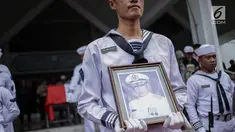Prajurit TNI AL membawa foto almarhum Amoroso Katamsi setelah disalatkan di Masjid Imam Bonjol, Pondok Labu, Jakarta, Senin (17/4). Upacara pemakaman pemeran Presiden Soeharto di film G30S/PKI itu dilakukan secara militer. (Liputan6.com/Faizal Fanani)