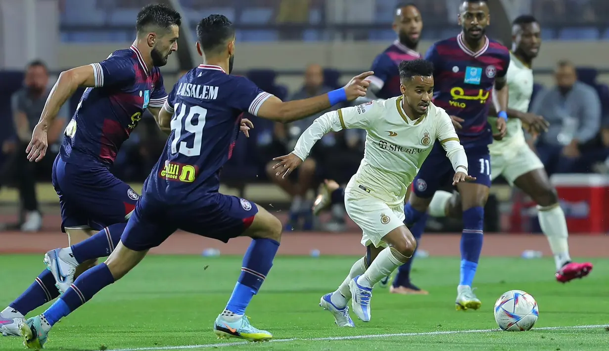 Gelandang Al Nassr FC, Abdulrahman Abdullah Ghareeb (kanan) menguasai bola di depan dua pemain Al Adalah pada laga pekan ke-22 Liga Arab Saudi 2022/2023 di Prince Abdullah Stadium, Rabu (5/4/2023) dini hari WIB. (twitter@AlNassrFC)