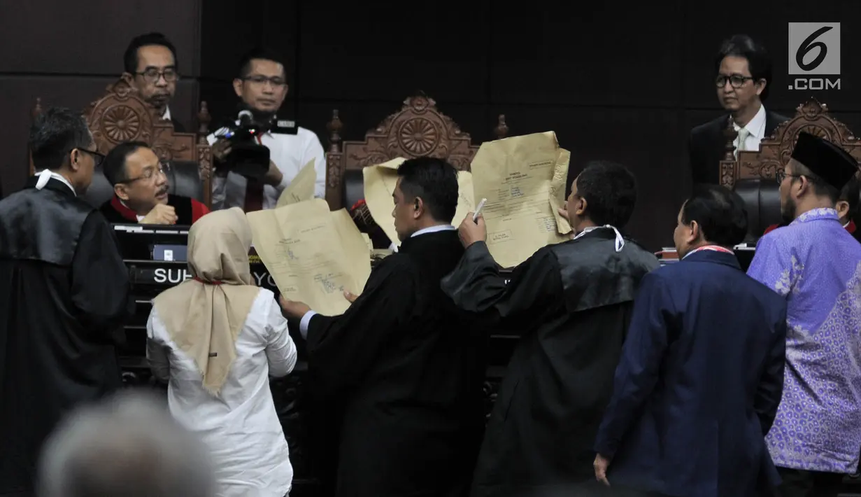 Saksi fakta Beti Kristiana menyerahkan barang bukti berupa amplop kepada majelis hakim dalam sidang sengketa Pilpres 2019 di MK, Jakarta, Rabu (19/6/2019). Beti memberi kesaksian terkait sengketa Pilpres 2019 untuk wilayah Jawa Tengah. (merdeka.com/Iqbal Nugroho)