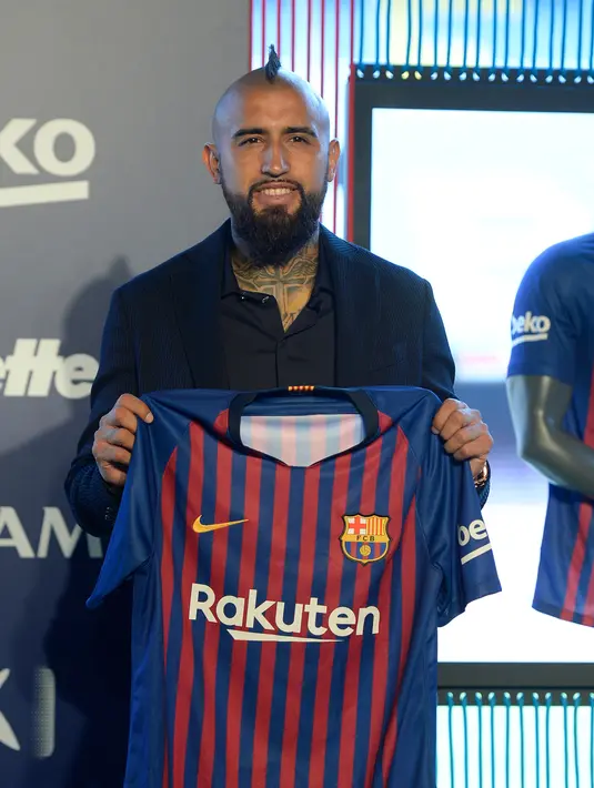 Pemain baru Barcelona, Arturo Vidal menunjukkan jersey Barcelona dalam presentasi resminya di Stadion Camp Nou, Barcelona, Spanyol, Senin (6/8). (Josep LAGO/AFP)