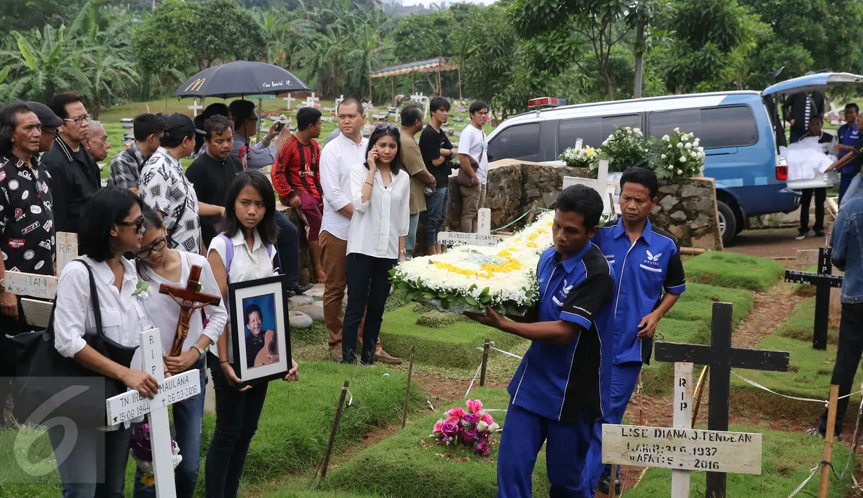 Karangan bunga berbentuk gitar ikut dibawa saat pemakaman Ireng Maulana di TPU Kampung Kandang, Jakarta, Senin (7/3/2016). Ireng Maulana menghembuskan napas terakhirnya di RS Harapan Kita pukul 00.15 WIB, Minggu (5/3/2016).(Liputan6.com/Herman Zakharia)