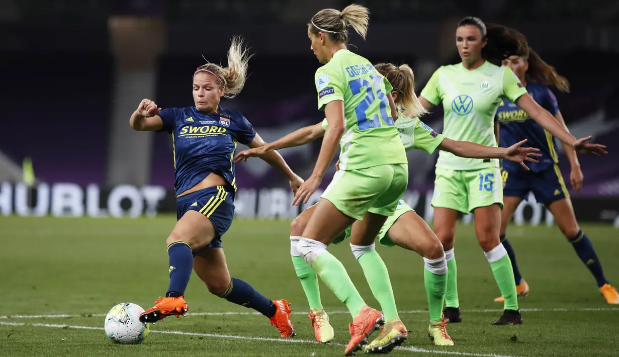 Pemain Lyon, Eugenie Le Sommer, berusaha melewati pemain Wolfsburg pada laga Liga Champions Wanita di Stadion Anoeta, Spanyol, Senin (31/8/2020). Lyon menang 3-1 atas Wolfsburg. (Clive Brunskill/Pool via AP)