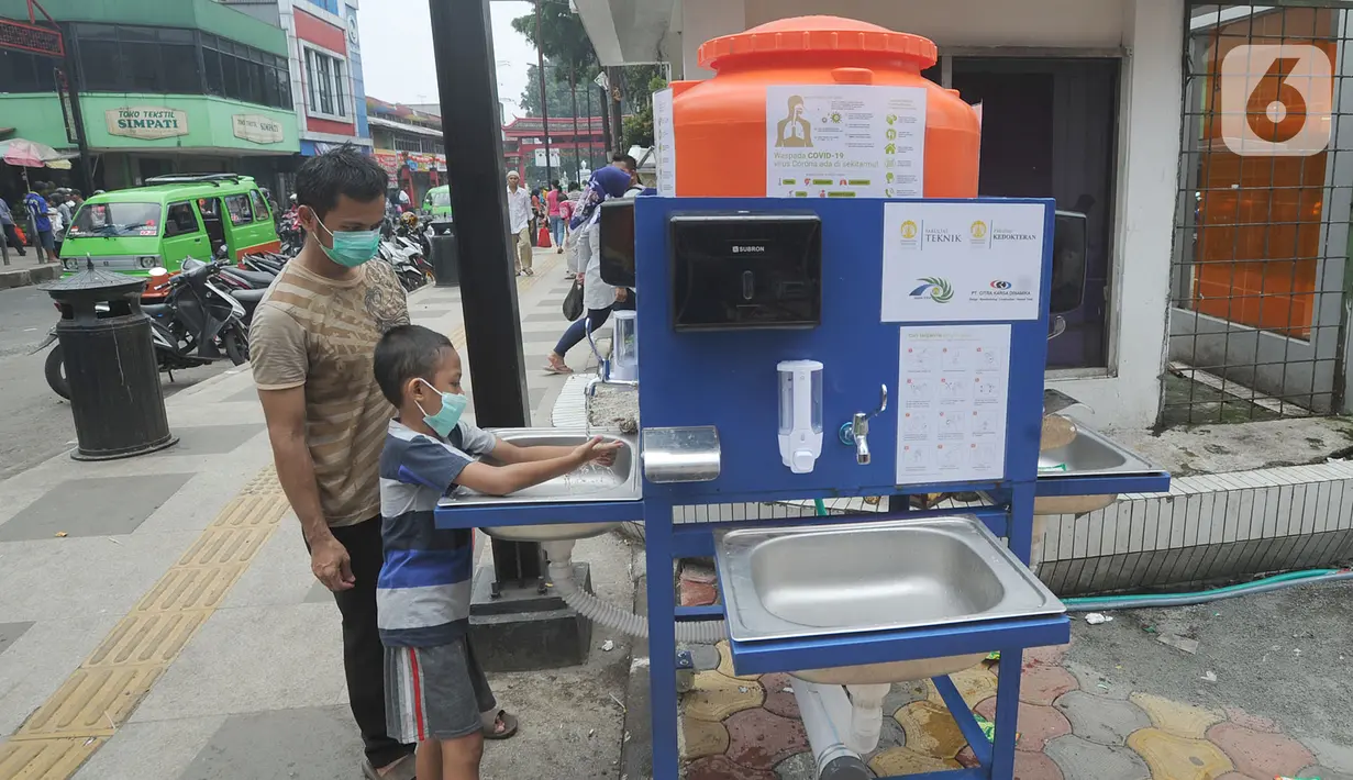 Warga menggunakan fasilitas tempat cuci tangan atau wastafel portabel di Pasar Bogor, Jalan Suryakencana, Kota Bogor, Sabtu (29/3/2020). Pemerintah Kota Bogor menerima bantuan berupa tempat cuci tangan portable dari Ikatan Alumni Teknik dan Alumni Ekonomi UI. (merdeka.com/Arie Basuki)