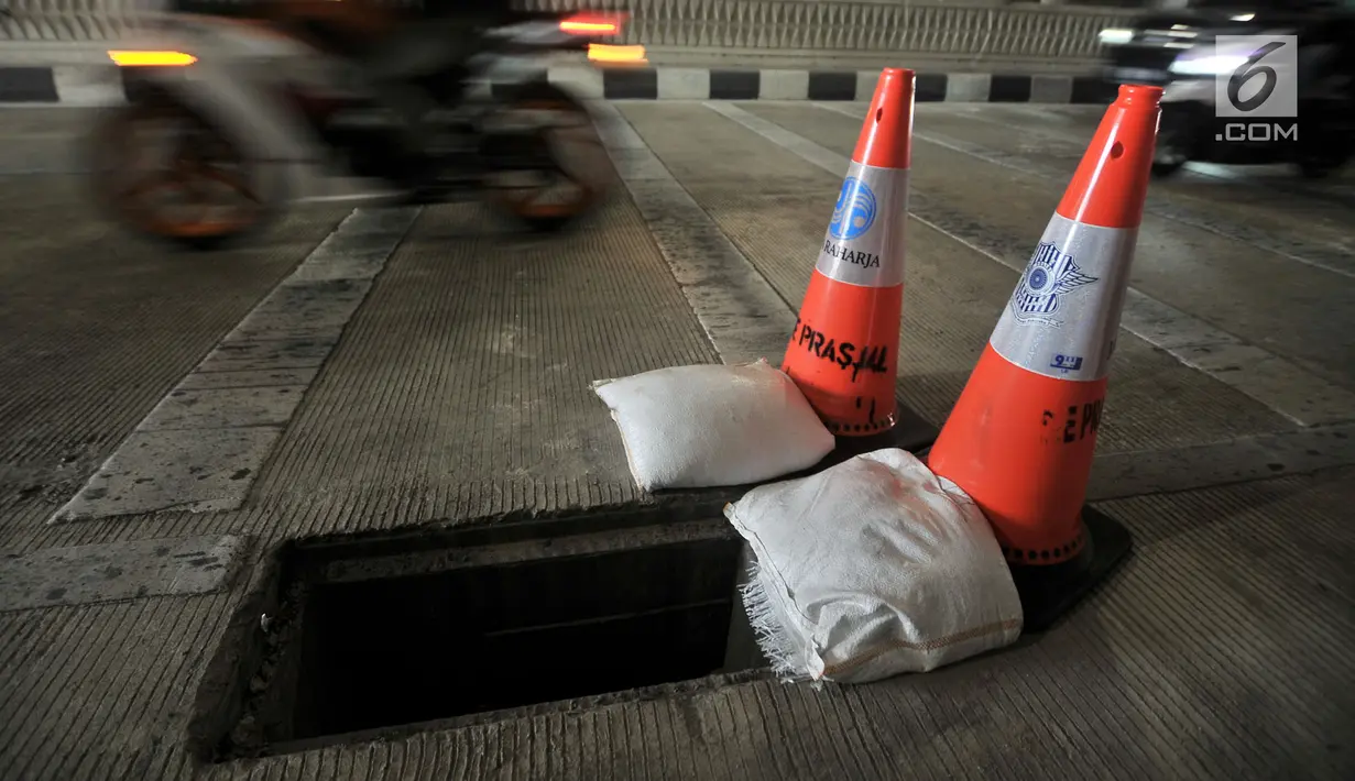 Pembatas jalan berwarna oranye diletakkan dekat penutup lubang saluran air yang hilang di Underpass Mampang-Kuningan, Jakarta, Kamis (23/8). Petugas menyadari hilangnya penutup saluran air itu usai salat Idul Adha. (Merdeka.com/Iqbal S. Nugroho)