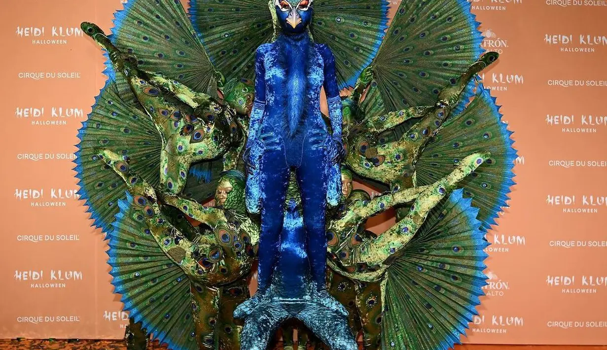 Tak ada yang lebih mengejutkan dari penampilan Heidi Klum di Halloween tahun ini. Ia memilih menjadi buruk merak. Ia bahkan meminta beberapa orang menjadi bulunya ketika merak memekarkan ekornya. Sang suami Tom Kaulitz menjadi telur burung. [Foto: Instagram/heidiklum]