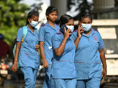 Petugas kesehatan mengenakan masker saat berjalan keluar dari rumah sakit pemerintah, sejak peningkatan kasus Covid-19, di Chennai pada 1 April 2023.  (AFP/R.Satish Babu)