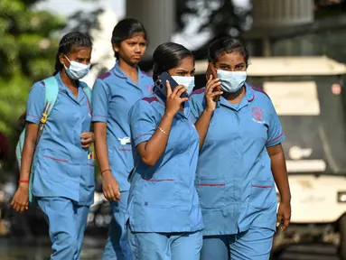 Petugas kesehatan mengenakan masker saat berjalan keluar dari rumah sakit pemerintah, sejak peningkatan kasus Covid-19, di Chennai pada 1 April 2023.  (AFP/R.Satish Babu)