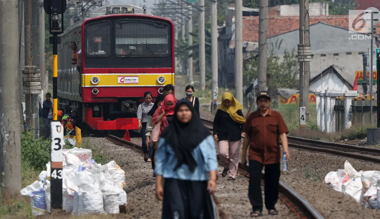 Sejumlah penumpang KRL Commuter Line terpaksa berjalan kaki menuju Stasiun Bojonggede, Bogor, Jawa Barat, Minggu (4/8/2019). Padamnya listrik di wilayah Jabodetabek mengakibatkan perjalanan KRL Commuter Line terhenti. (Liputan6.com/Helmi Fithriansyah)