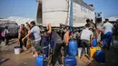 Situasi ini mengakibatkan lumpuhnya sistem air sekaligus dan mengancam kehidupan pengungsi Palestina di Gaza. Tampak dalam foto, para pengungsi Palestina berkumpul untuk mengambil air dari sebuah truk di kamp tenda darurat, Khan Younis, Jalur Gaza Selatan, Kamis 30 April 2026. (AP Photo/Abdel Kareem Hana)