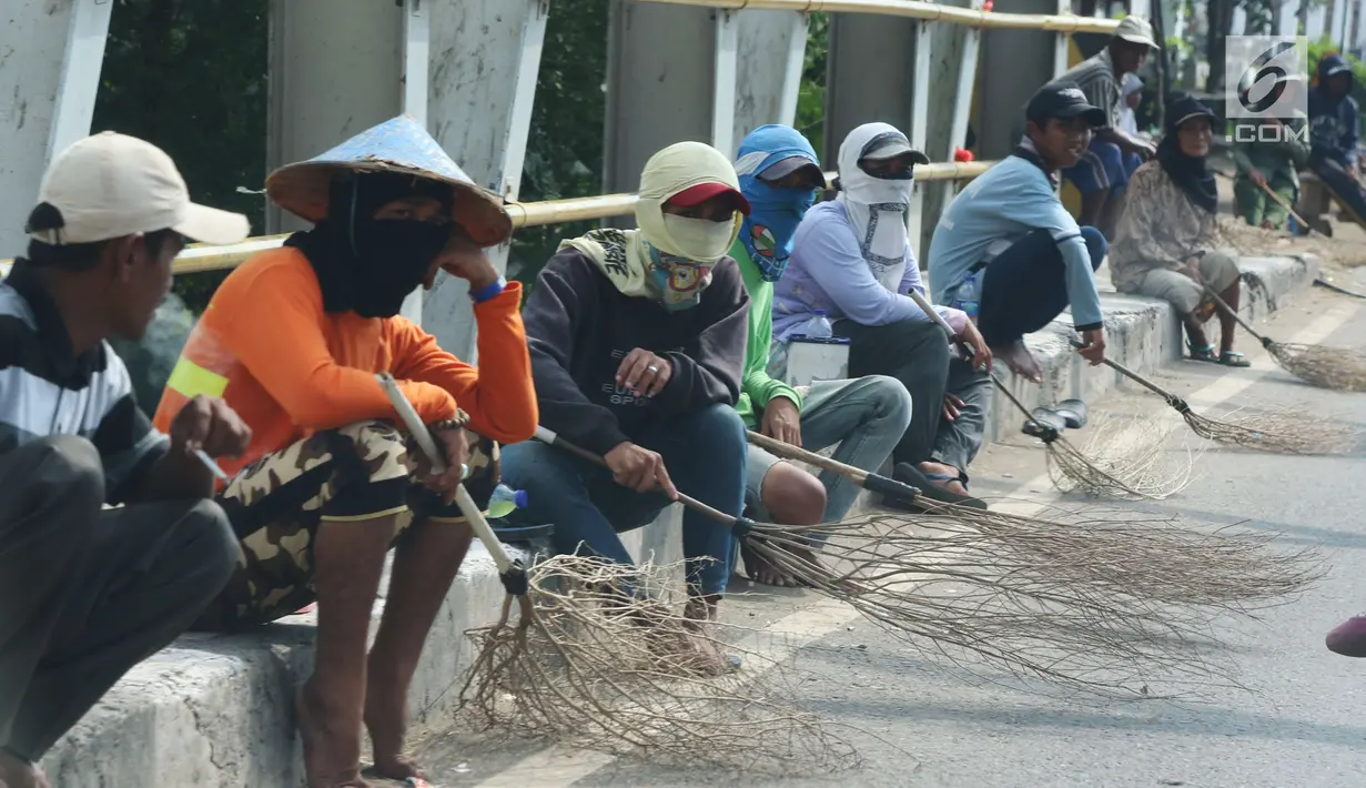 Sejumlah penyapu koin duduk sambil menunggu koin yang dilempar ke jalan di kawasana Subang, Jawa Barat, Sabtu (7/1). Pasca Lebaran warga yang menjadi penyapu uang koin menjadi banyak dibanding hari biasanya. (Liputan6.com/Helmi Afandi)