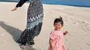 Berada di pantai, Ria mengenakan dress bermotif bernuansa hitam dan Moana dengan dress pinknya. [@riaricis1795]