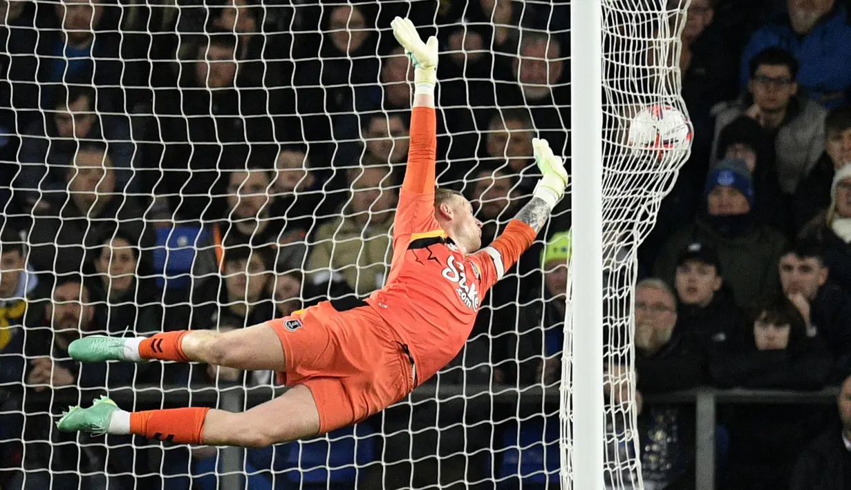 Kiper Everton, Jordan Pickford gagal menghalau bola tendangan Callum Wilson yang berbuah menjadi gol ketiga Newcastle United pada laga pekan ke-33 Liga Inggris 2022/2023 di Goodison Park, Liverpool, Jumat (28/04/2023) dini hari WIB. The Magpies sukses menghajar tuan rumah dengan skor 4-1. (AFP/Oli Scarff)