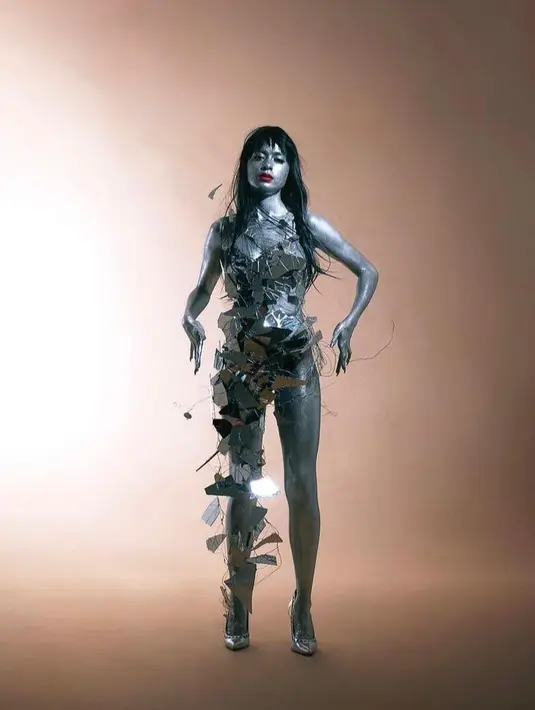 Untuk melengkapi look-nya yang kece banget ini, wajah cantik Eva Celia dihias lipstik merah menyala dan bulu mata tebal. Ia juga muncul dengan memakai wig hitam panjang berponi rata. (Instagram/evacelia).