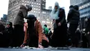 Sejumlah wanita muslim bergegas usai melakukan salat berjemaah sebelum melakukan aksi protes di Manhattan, New York (1/2). Mereka menentang kebijakan Presiden Donald Trump melarang warga tujuh negara Muslim masuk AS. (AFP/Spencer Platt)