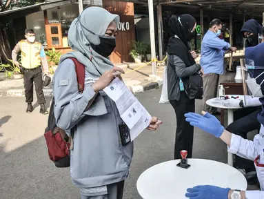 Calon penumpang KRL menunjukkan surat saat pemeriksaan Surat Tanda Registrasi Pekerja (STRP) di Stasiun Bekasi, Jawa Barat, Selasa (13/7/2021). KAI Commuter mewajibkan calon penumpang KRL menunjukkan STRP sebagai syarat perjalanan selama masa PPKM Darura. (merdeka.com/Iqbal S. Nugroho)