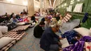 Selama 10 hari terakhir bulan suci Ramadan, membaca Al Quran menjadi aktivitas utama bagi mereka yang menjalankan Itikaf. Tampak dalam foto, umat Muslim Syiah, termasuk pengunjung dari Iran dan lainnya, membaca Al-Quran, saat melaksanakan Itikaf di Masjid Kufa, selatan Baghdad, Irak, pada 12 Maret 2026. (Qassem al-KAABI/AFP)