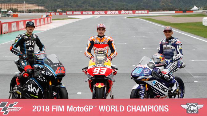 Juara Dunia MotoGP Marc Marquez (tengah) berpose bersama Juara Dunia Moto2 Francesco Bagnaia (kiri) dan Juara Dunia Moto3 Jorge Martin (kanan) usai Grand Prix Valencia di sirkuit Ricardo Tormo, Cheste, Spanyol, Minggu (18/11). (AP Photo/Alberto Saiz)