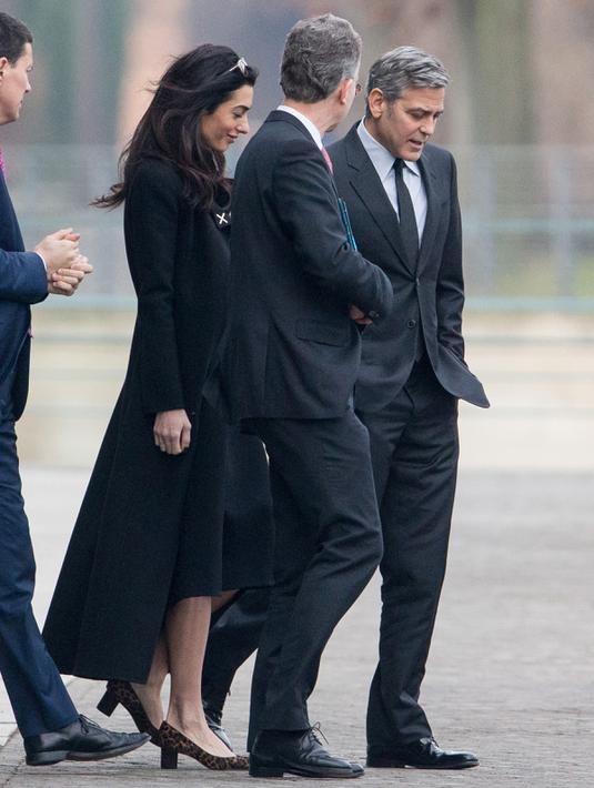 Aktor AS, George Clooney dan istrinya, Amal Alamuddin usai menemui Kanselir Jerman, Angela Merkel (kedua kiri) di Berlin, Jerman, Jumat (12/2). Pertemuan keduanya guna membahas krisis pengungsi di Eropa. (Kay NIETFELD/DPA/AFP)