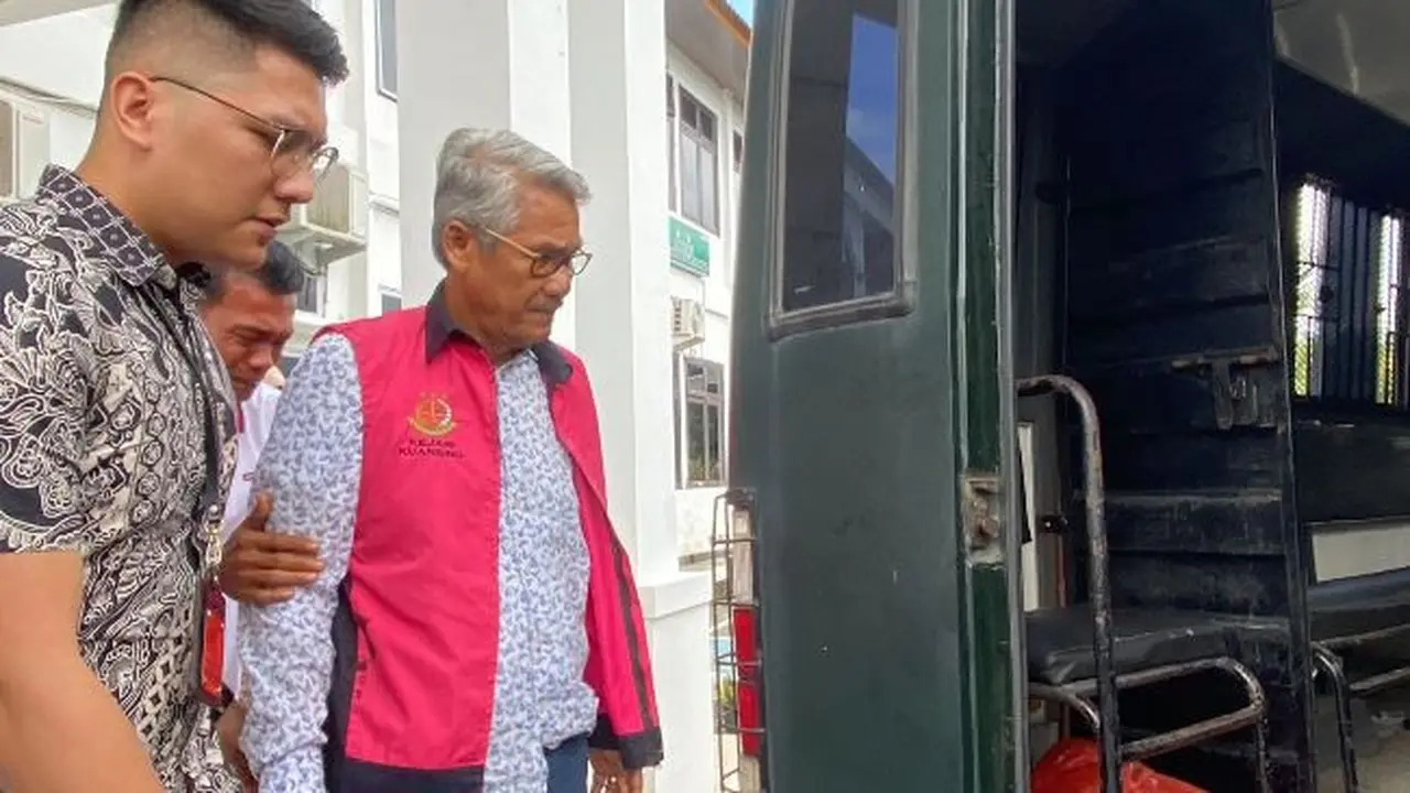 Mantan Bupati Kuansing Sukarmis digiring penyidik ke mobil tahanan setelah menjadi tersangka korupsi hotel Kuansing.