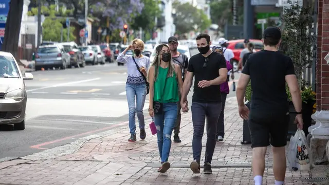 Orang-orang memakai masker mencegah COVID-19 di kawasan perniagaan Cape Town, Afrika Selatan
