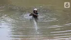 Warga menjaring ikan di galian properti kawasan Kampung Sawah, Ciputat, Tangerang Selatan, Senin (13/7/2020). Masa pandemi Covid-19, warga memanfaatkan waktu luang dengan menjaring ikan untuk menyambung hidup. (Liputan6.com/Fery Pradolo)