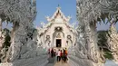 Sejumlah turis saat melakukan tur di Wat Rong Khun atau kuil putih di Provinsi Chiang Mai, Thailand, Jumat (4/3). Kuil Putih dirancang oleh seniman visual Thai Chalermchai Kositpipat. (REUTERS / Jorge Silva)