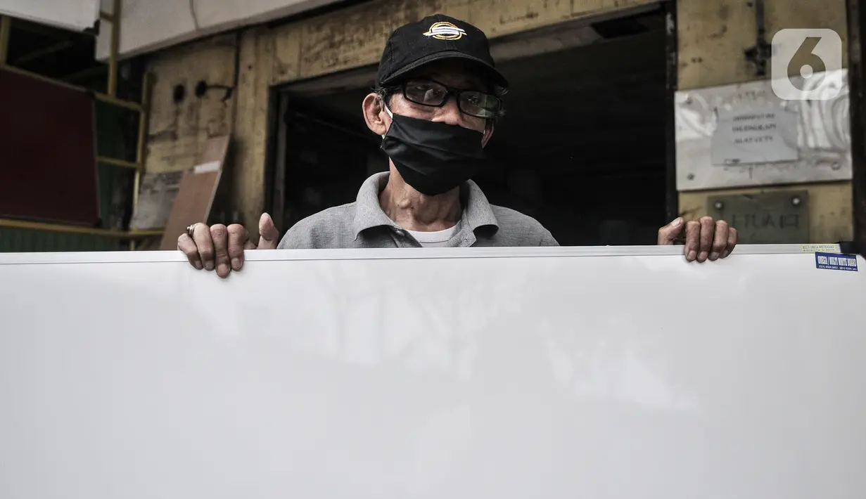 Pekerja merapikan papan tulis yang dipajang di depan toko di kawsan Jakarta, Rabu (3/3/2021). Selama pandemi, rata-rata dalam sehari sebanyak 15 buah papan tulis laris terjual berkat pemasaran online. (merdeka.com/Iqbal S Nugroho)