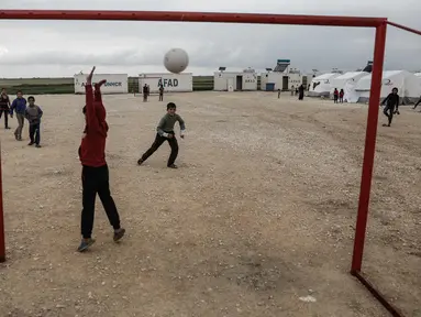 Seorang anak pengungsi Suriah menjaga gawangnya saat bermain sepak bola di sebuah kamp di al-Bil, timur dari kota Azas yang dikuasai pemberontak di Suriah utara (21/4). (AFP Photo/Sameer Al-Doumy)