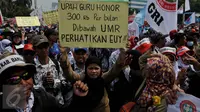 Pengunjuk rasa membawa karton bertuliskan tuntutan mereka saat menggelar aksi mogok dan unjuk rasa di depan gedung DPR/MPR, Jakarta, Selasa (15/9). Para guru honorer itu menuntut Pemerintah mengangkat mereka menjadi PNS. (Liputan6.com/Johan Tallo)