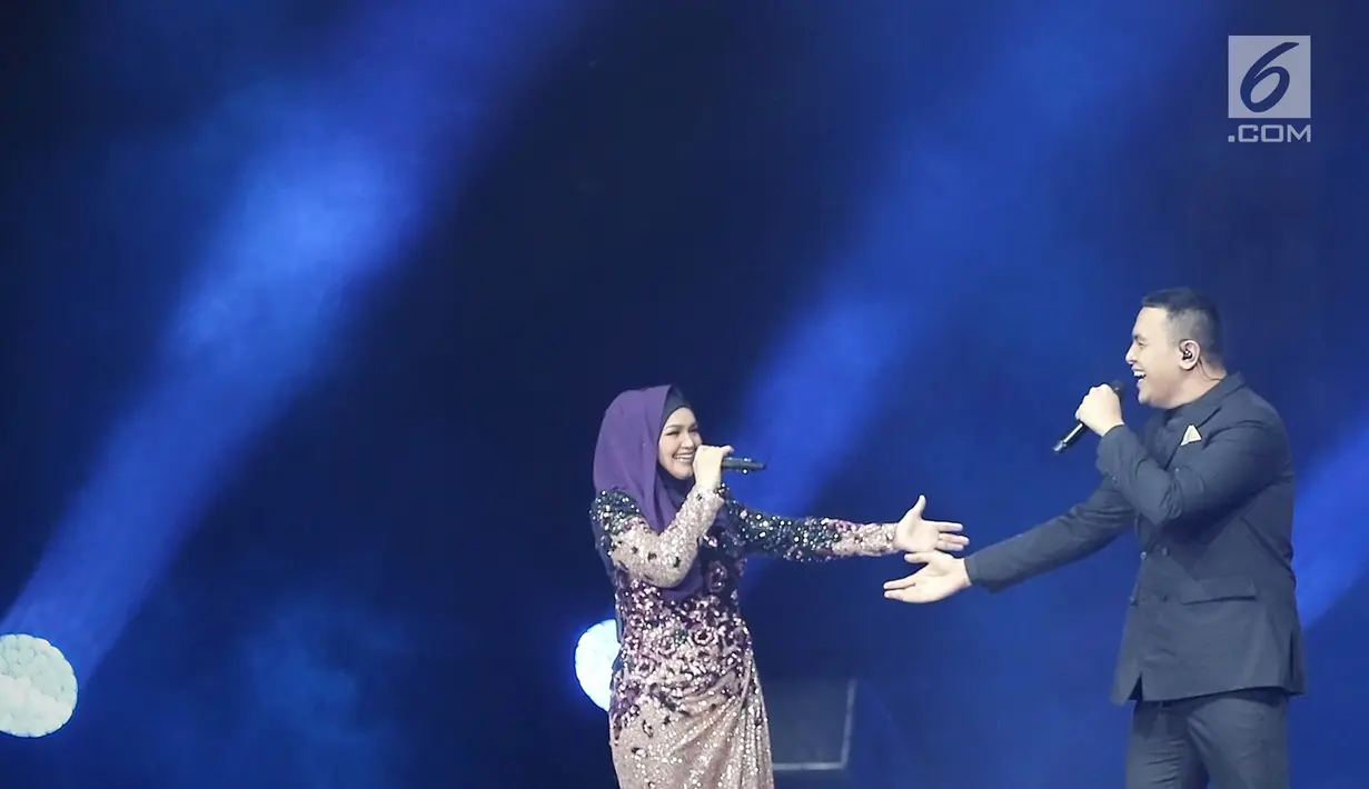 Penyanyi Siti Nurhaliza (kiri) berduet dengan Tulus dalam konser 'Dato Sri Siti Nurhaliza on Tour' di Istora Senayan, Jakarta, Kamis (21/2). Siti mengaku gugup saat berduet dengan Tulus. (Fimela.com/Bambang E Ros)