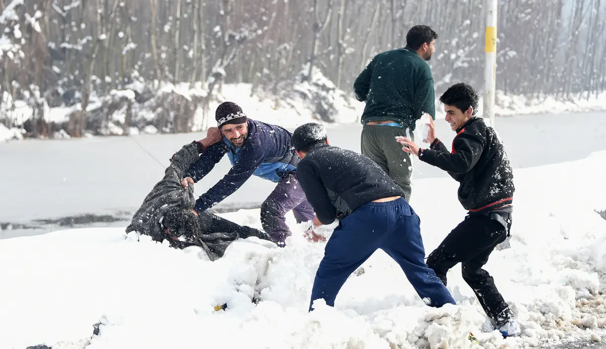 Pemuda Kashmir bermain dengan salju di tepi Danau Dal setelah salju turun di Srinagar, India bagian utara, Sabtu (5/1). Wilayah Kashmir mengalami salju selama beberapa hari yang mengakibatkan terputus jalan raya Jammu-Srinagar. (TAUSEEF MUSTAFA/AFP)