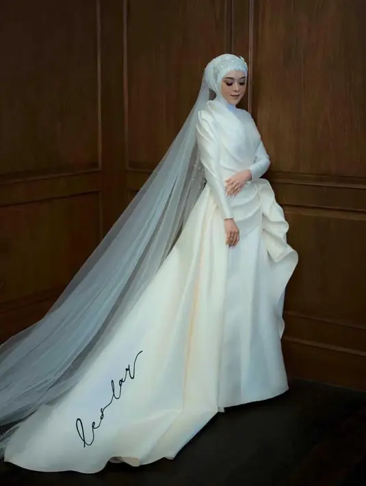 Pengantin dengan kerudung juga bisa menambahkan veil panjang seperti yang dikenakan Lesti Kejora saat mengenakan gaun putih lengan panjang. [@lestykejora]