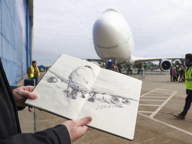 Seniman Jeff Barlow dari departemen kreatif Boeing memamerkan sketsa pesawat Boeing 747 terakhir dalam sebuah upacara untuk menandai pengirimannya, di Boeing Future of Flight Museum di Everett, Washington, pada 31 Januari 2023. Boeing mengirimkan pesawat seri 747 terakhir mereka ke Atlas Air, Selasa sore. (Jason Redmond / AFP)