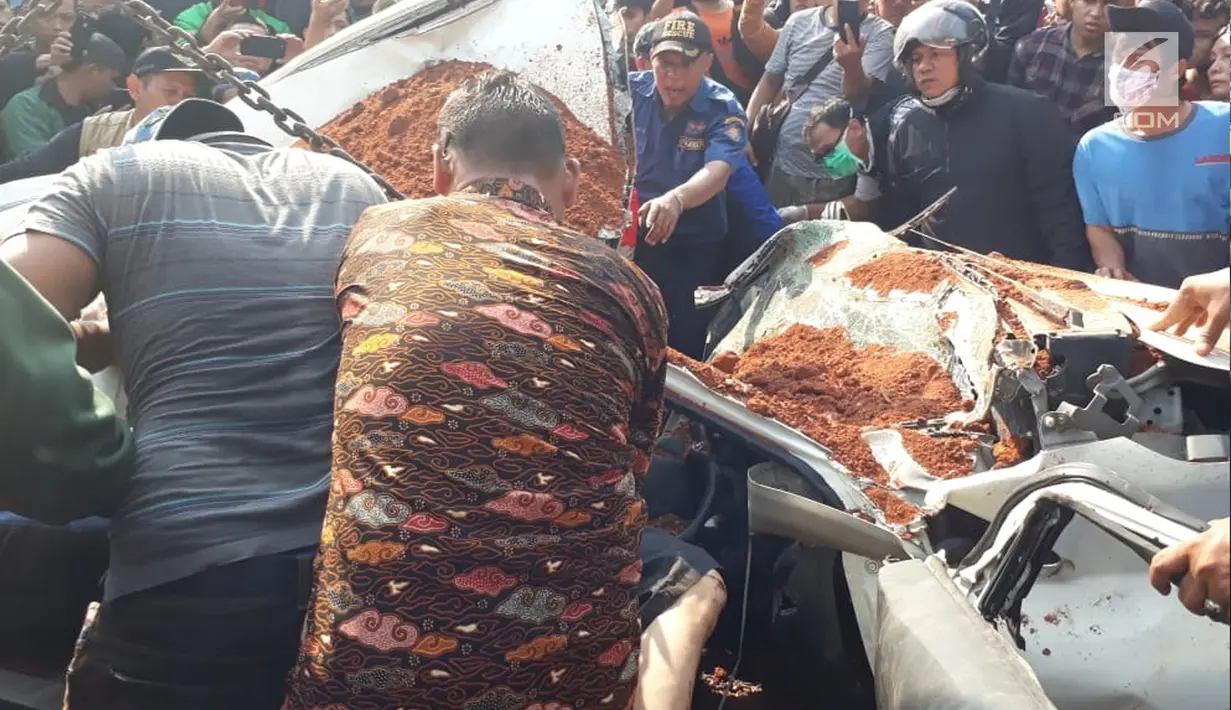 Petugas bersama warga berusaha mengevakuasi korban dalam kecelakaan maut antara truk pengangkut tanah dengan mobil penumpang di Karawaci, Tangerang, Kamis (1/8/2019). Lima orang penumpang minibus menjadi korban, empat orang diantaranya meninggal dunia. (Liputan6.com/Pramita Tristiawati)